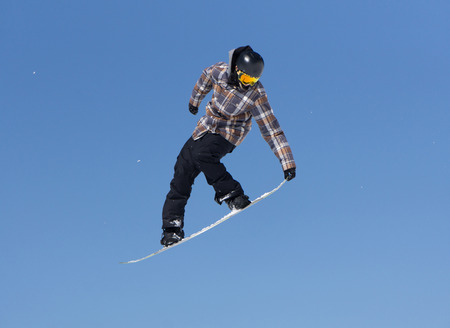 Snowboarder jumps in Snow Park, mountain ski resort