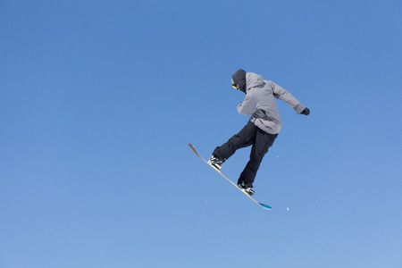 Snowboarder jumps in Snow Park, big airの写真素材