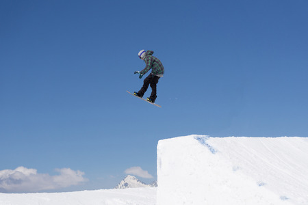 Snowboarder jumps in Snow Park, big airの写真素材