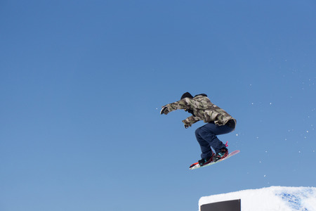 Snowboarder jumps in Snow Park, big airの写真素材