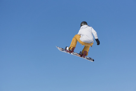 Snowboarder jumps in Snow Park, big airの写真素材