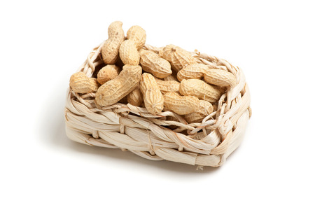 unshelled peanuts peanuts isolated in basket on white backgroundの写真素材