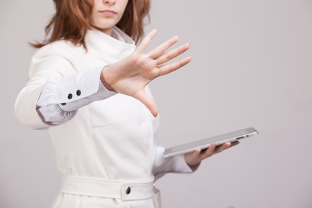 Young girl working with virtual screen on gray background