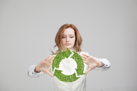 Young woman holding green recycle symbol in his handsの写真素材