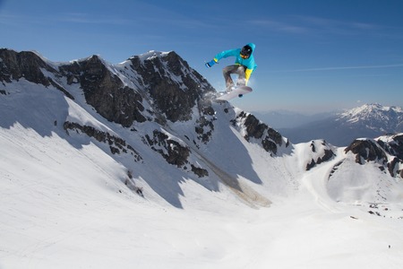 Flying snowboarder on mountains, extreme sport