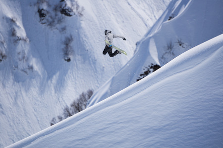 Flying snowboarder on mountains, winter extreme sportの写真素材