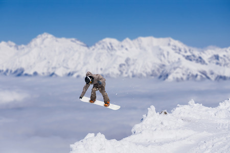 Flying snowboarder on mountains. Extreme winter sportの写真素材