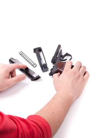 Isolated disassembled gun and hands on white backgroundの写真素材