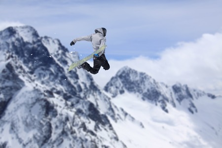 Flying snowboarder on mountains. Extreme winter sport.の写真素材