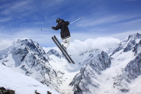 Flying skier on mountains. Extreme winter sport.の写真素材