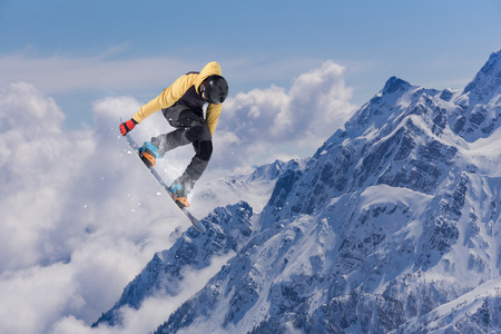 Flying snowboarder on mountains. Extreme winter sport.の写真素材