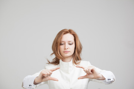 Young girl working with virtual screen on gray background