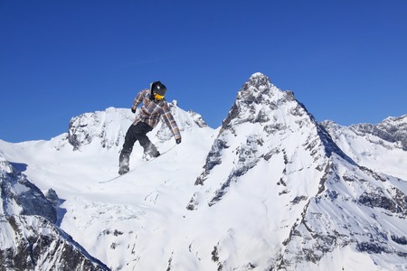 Flying snowboarder on mountains. Extreme winter sport.の写真素材