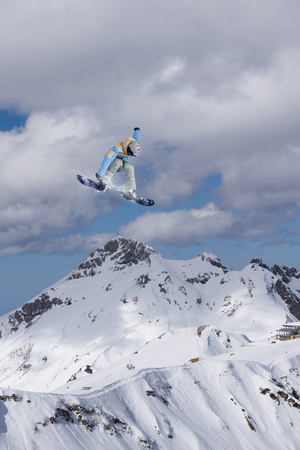 Flying snowboarder on mountains. Extreme winter sport.の写真素材