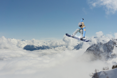 Flying snowboarder on mountains. Extreme winter sport.の写真素材