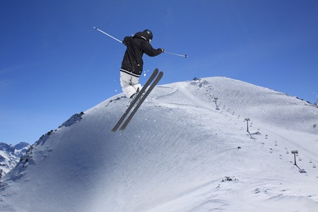 Flying skier on mountains. Extreme winter sport.の写真素材