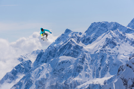 Flying snowboarder on mountains. Extreme winter sport.の写真素材