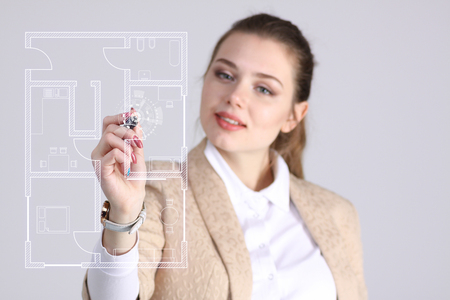Young woman architect working with a virtual apartment planの写真素材