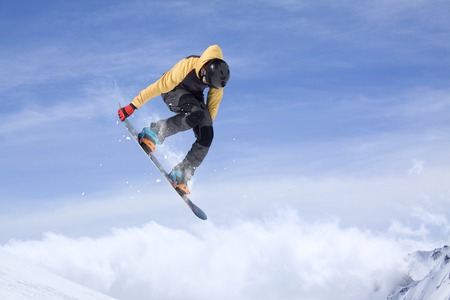 Flying snowboarder on mountains. Extreme winter sport.の写真素材