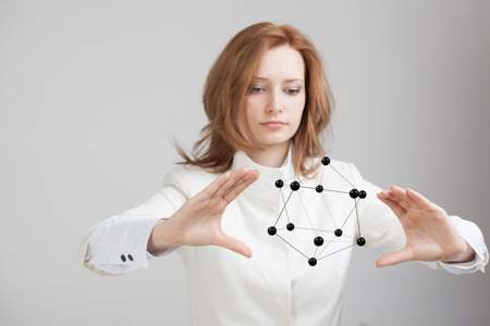 Young woman scientist holding model of molecule or crystal lattice.の写真素材