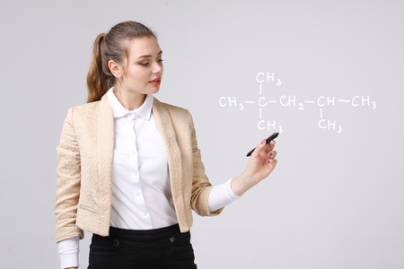 Woman chemist shows a molecular structure, on gray backgroundの写真素材