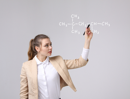 Woman chemist shows a molecular structure, on gray backgroundの写真素材