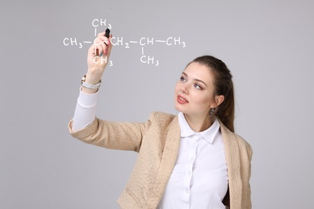 Woman chemist shows a molecular structure, on gray backgroundの写真素材
