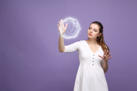 Woman with glowing magical energy ball on purple background.の写真素材