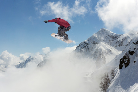 Snowboarder jumping on mountains. Extreme winter sport.の写真素材