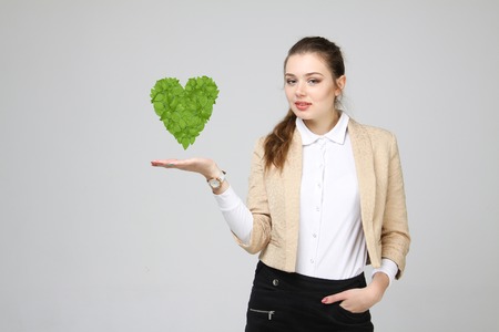 Young woman holding green plant heart in her handsの写真素材