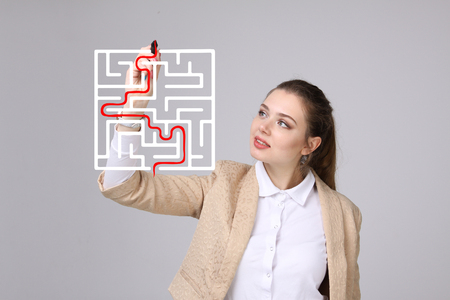 Young businesswoman finding the maze solution writing on whiteboard.の写真素材