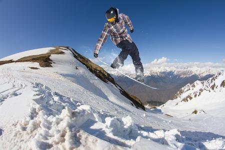 Snowboarder jumping on mountains. Extreme winter sport.の写真素材