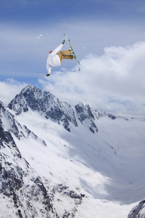 Flying skier on mountains. Extreme winter sport.の写真素材