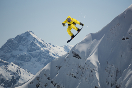 Snowboard rider jumping on mountains. Extreme snowboard freeride sport.の写真素材