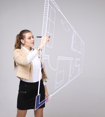 Female architect working with a virtual apartment plan. Virtual house design software.の写真素材