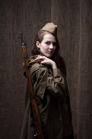 Young woman in Russian military uniform with rifle. Female soldier during the second world war.の写真素材