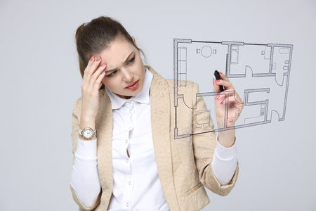 Female architect working with a virtual apartment plan. Virtual house design software.の写真素材