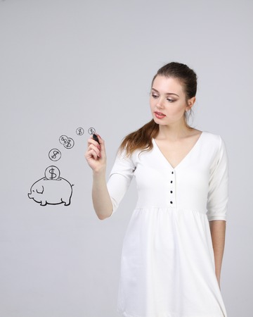 young businesswoman, woman drawing a piggy Bankの写真素材