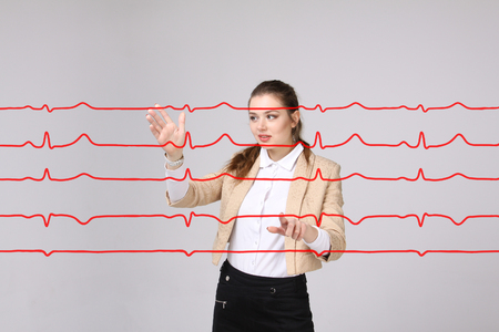 Young doctor woman working with cardiogram. Electrocardiogram lines in airの写真素材