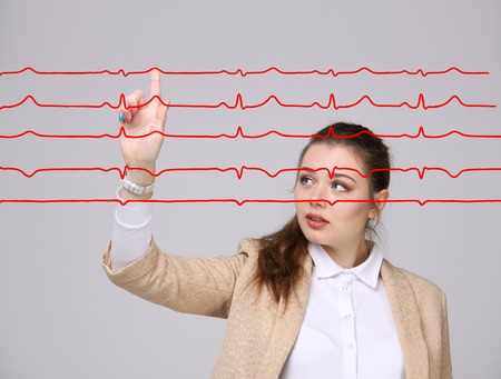 Young doctor woman working with cardiogram. Electrocardiogram lines in airの写真素材