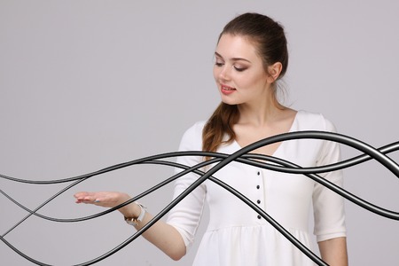 Young woman with electrical cables or wires, curved linesの写真素材