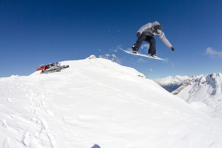 Snowboard rider jumping on snowy mountains. Extreme snowboard freeride sport.の写真素材