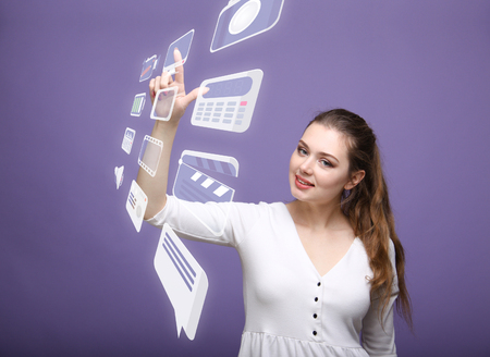 Young woman pressing multimedia and entertainment icons on a virtual background
