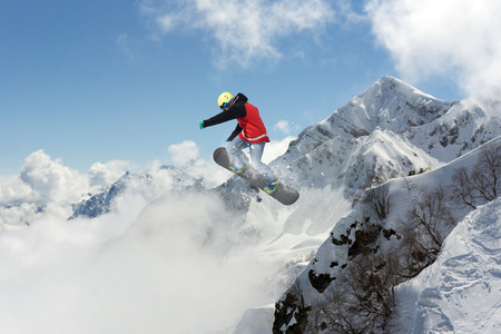 Snowboard rider jumping on snowy mountains. Extreme snowboard freeride sport.の写真素材