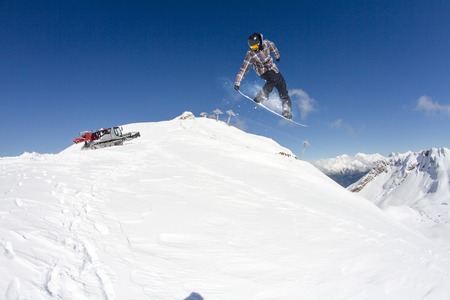Snowboard rider jumping on snowy mountains. Extreme snowboard freeride sport.の写真素材