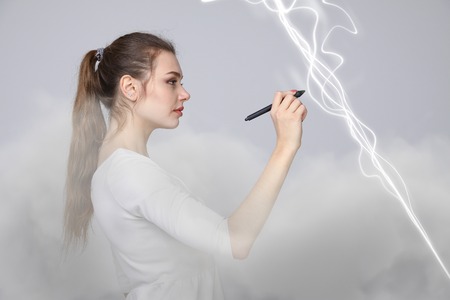 Young woman making magic effect - flash lightning. The concept of electricity, high energy.