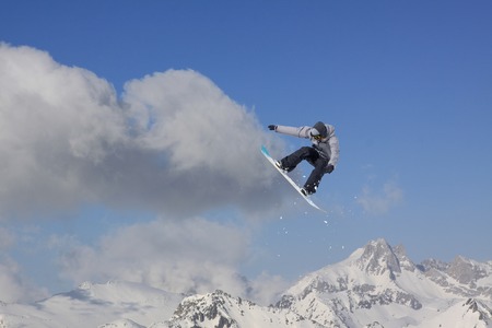 Snowboard rider jumping on snowy mountains. Extreme snowboard freeride sport.の写真素材