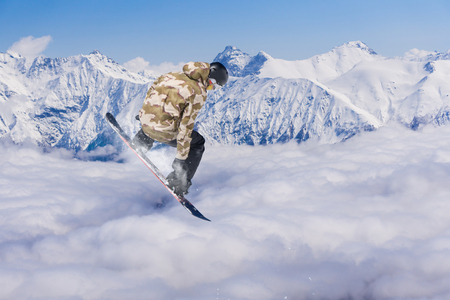 Snowboard rider jumping on snowy mountains. Extreme snowboard freeride sport.の写真素材
