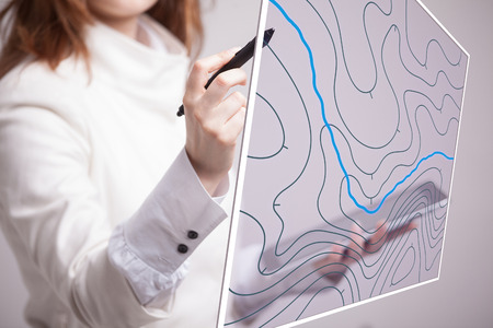 Geographic information systems concept, woman scientist working with futuristic interface in GIS software on a transparent screen.の写真素材
