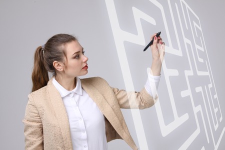 Young businesswoman finding the maze solution writing on whiteboard.